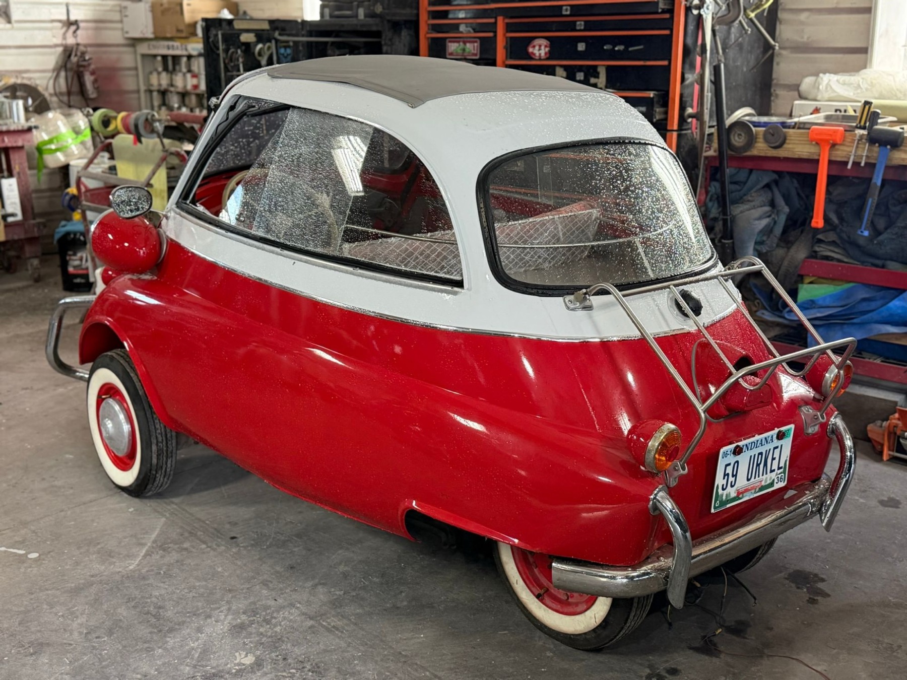 Back of a red and white BMW Isetta with a chrome luggage rack