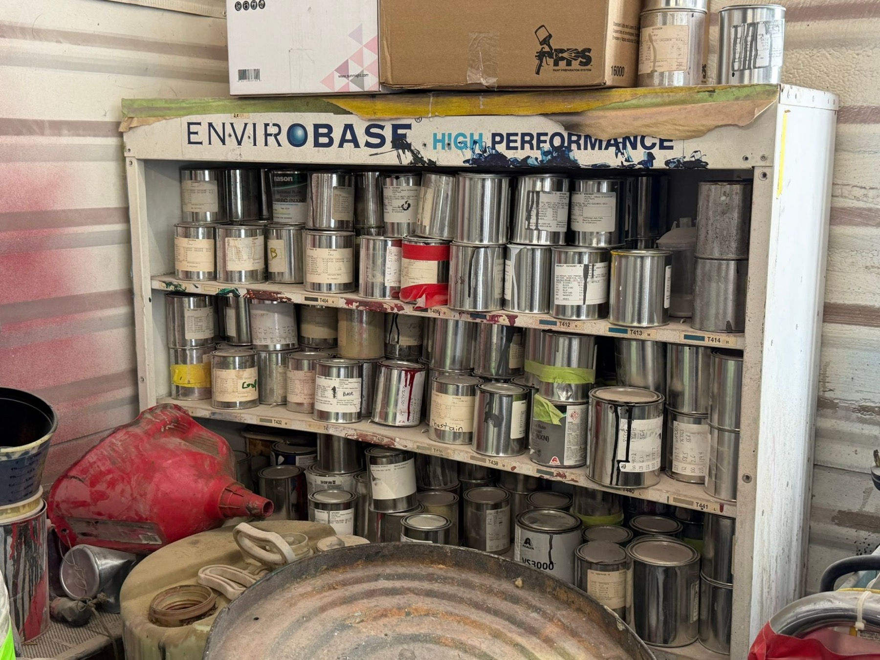 Shelves of basecoat paint cans in the shop paint room